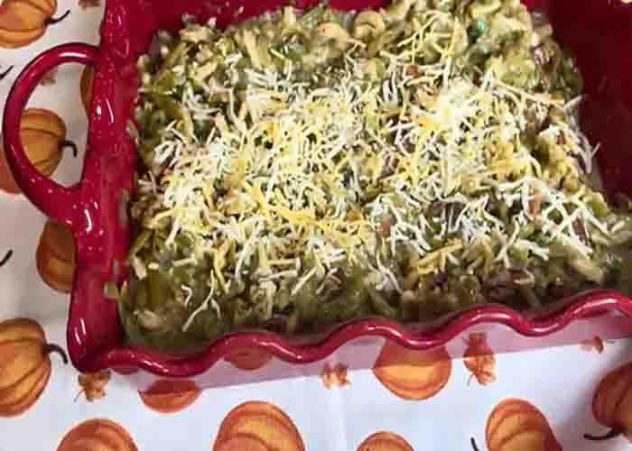 Topping the fall green bean casserole with shredded cheese