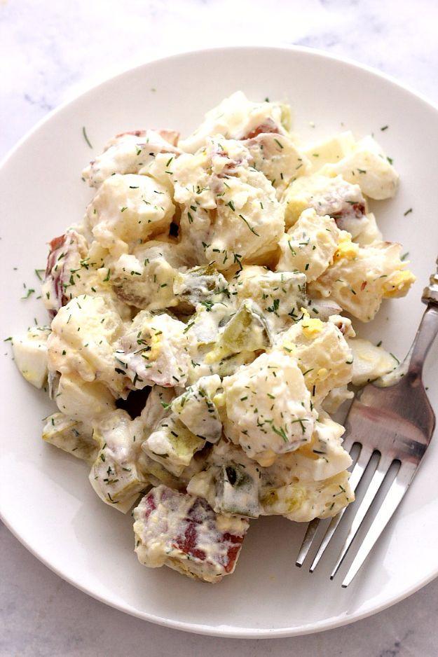 Plate of creamy dill pickle salad with red skins and chopped hard boiled egg, a fork resting alongside
