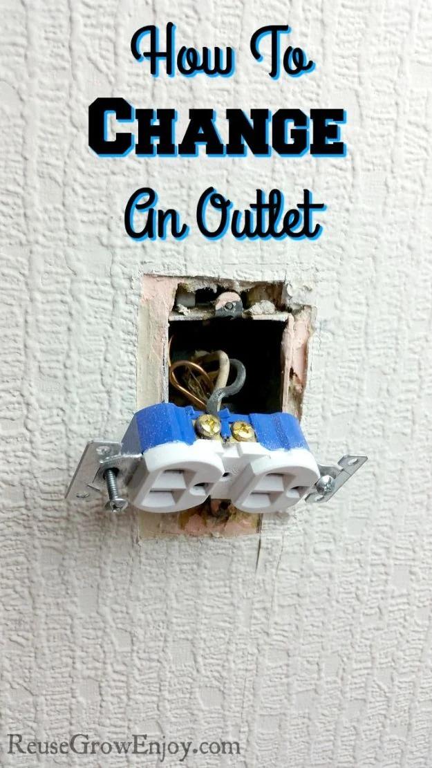 Change an outlet, an outlet pulled out of a textured white wall on blue-taped terminals with wiring visible inside the box