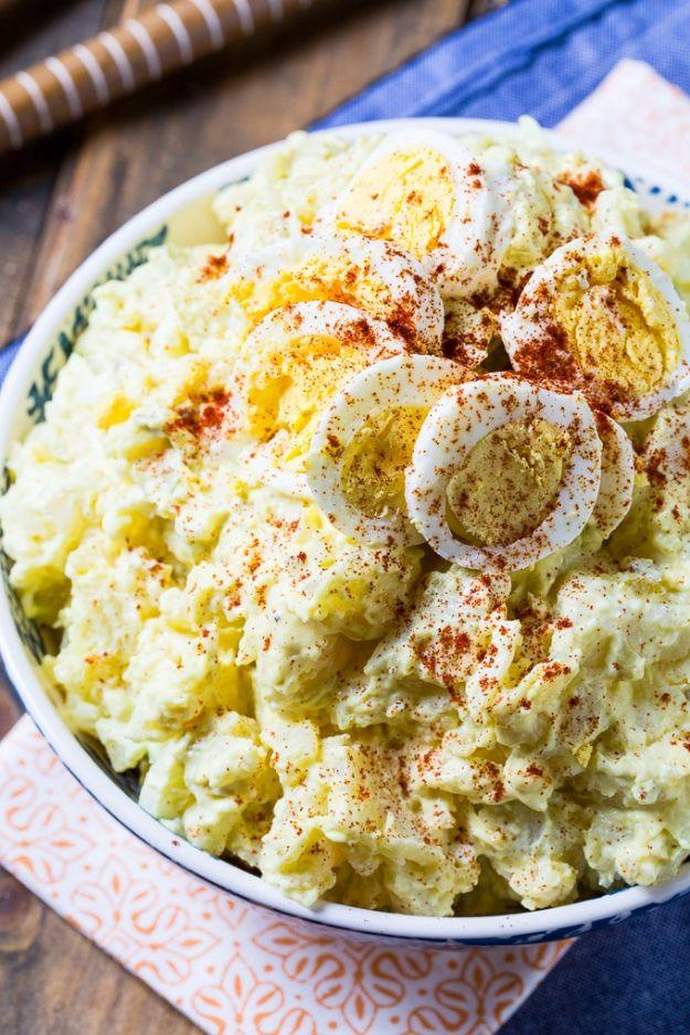 White bowl of creamy southern potato salad topped with sliced hard boiled egg and a dusting of paprika