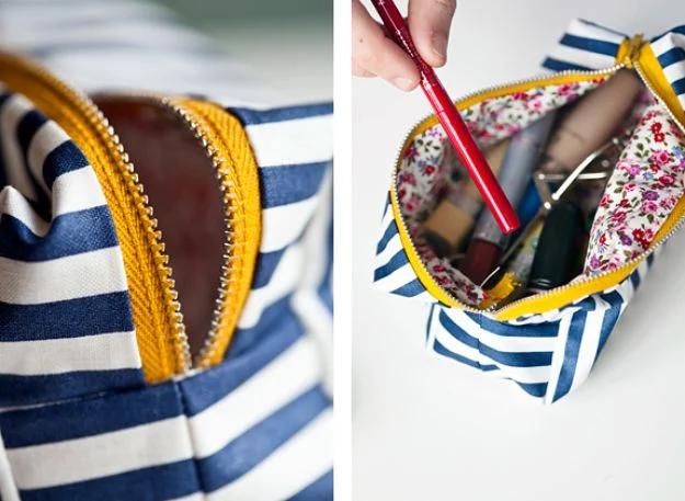 A boxy little makeup bag in floral cotton, unzipped to show a wipeable laminated lining and boxed corners.