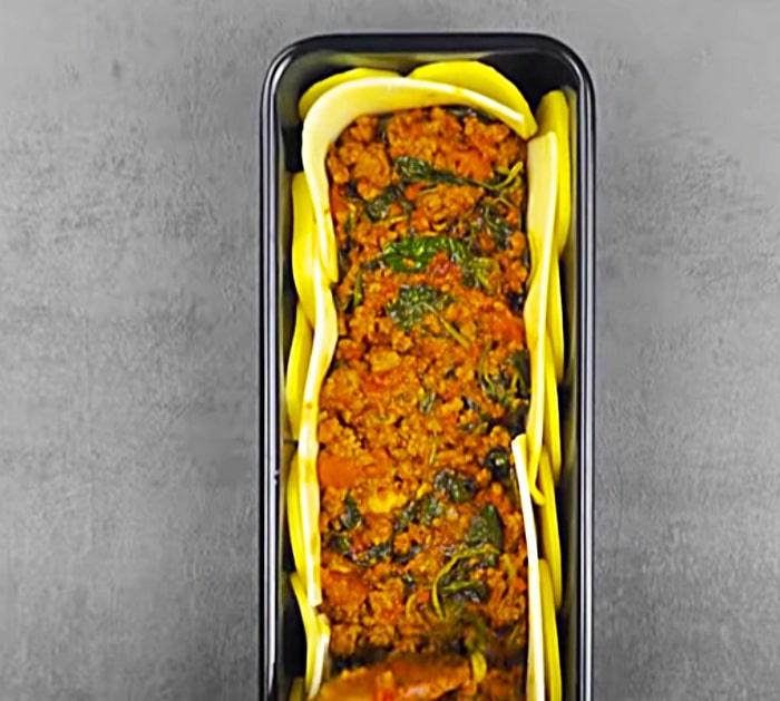Scalloped potato casserole with spinach and spaghetti sauce in a loaf pan