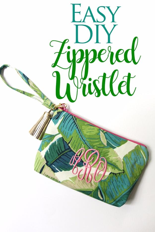 Green banana leaf print zippered wristlet with a pink monogram, gold hardware and a cream leather tassel on white