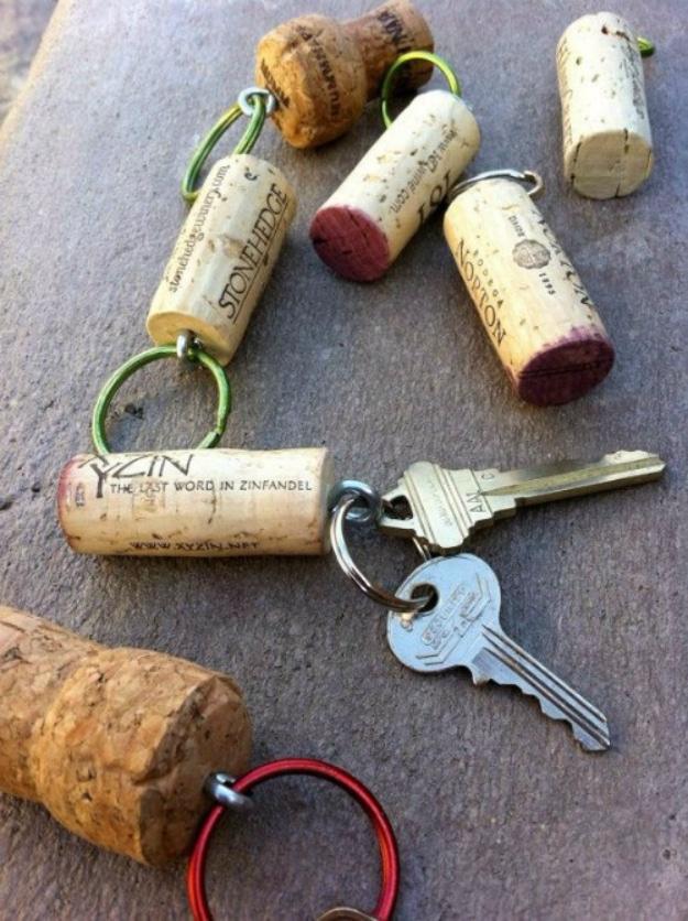 Several wine corks fitted with keyring hardware lying on concrete, one attached to a set of car keys