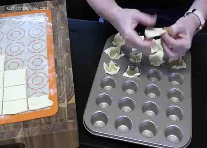Adding the Pilsbury dough to the muffin tin