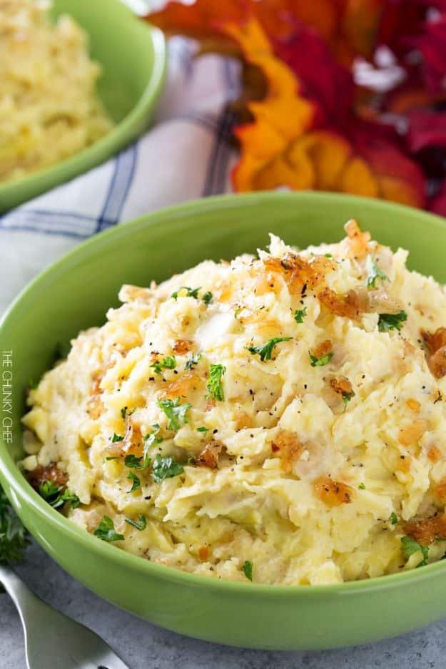 Horseradish mashed potatoes in a bowl topped with golden caramelized onions and minced fresh parsley