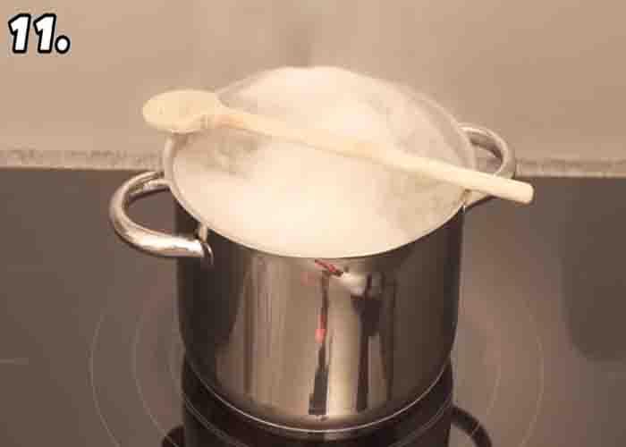 Placing a wooden spoon over a pot of boiling water to avoid spillage.