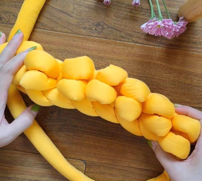Hand knit chunky yarn bag tutorial showing the bulky cotton tube yarn looped into chains by hand without needles
