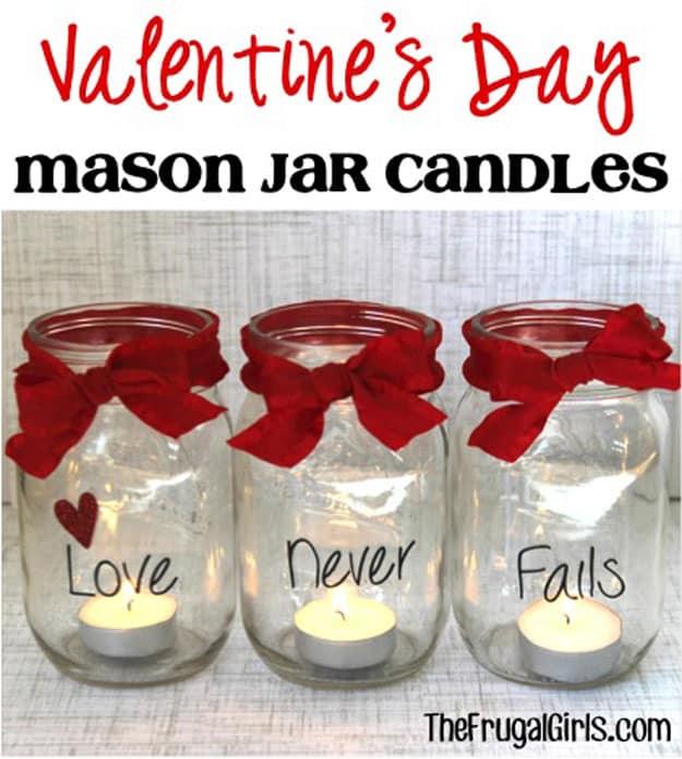 Mason jars with handwritten Sharpie messages and ribbon holding tea lights on a kitchen counter in pink and red