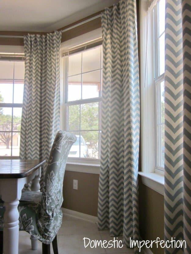 DIY bay window curtain rod and back tab curtains, gray chevron panels hung across a bay window in a dining room