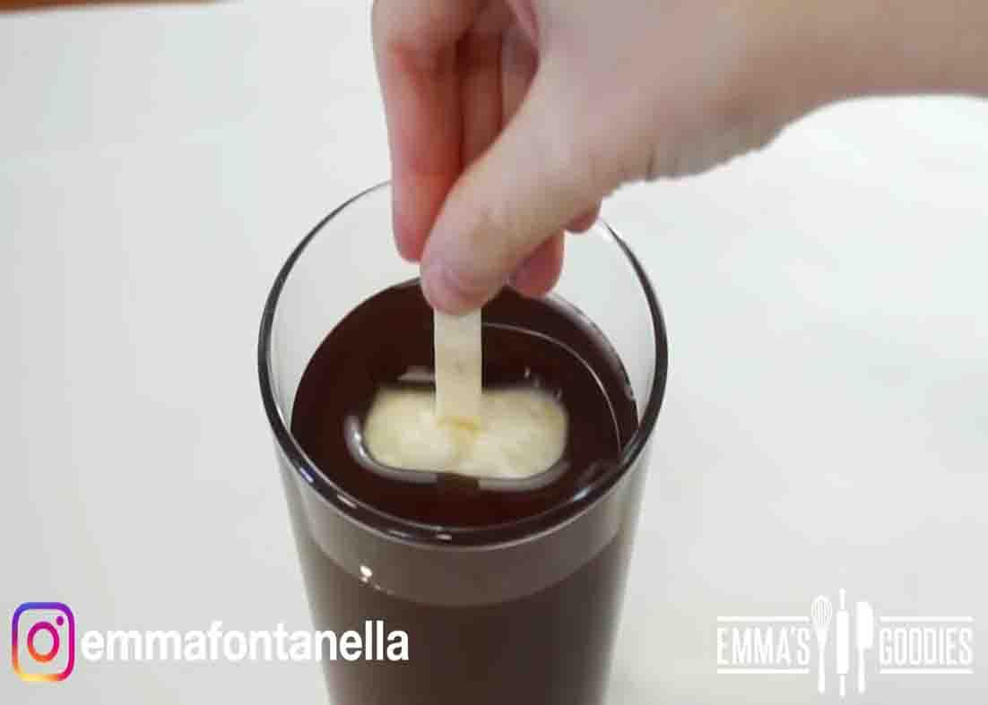 Dipping the ice cream bars in the chocolate mixture