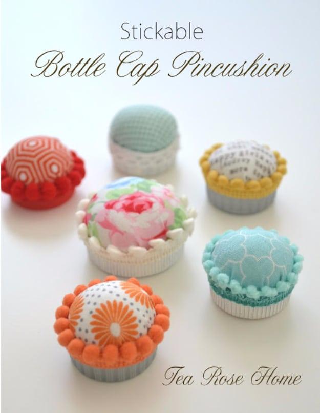A bottle cap pincushion topped with a puff of printed fabric, stuck to the side of a sewing machine with pins in it