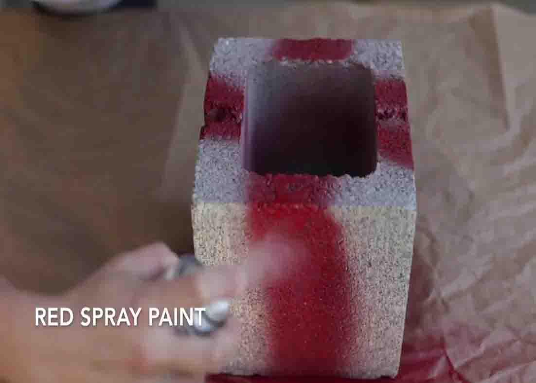 Spraying the sides of the cinder block to make the DIY cinder block present decor
