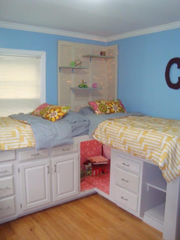 Beds with storage, two corner beds built on white kitchen cabinets with drawers below and a lit play nook between them