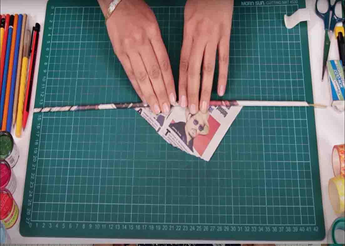 Rolling the newspaper to make a coaster