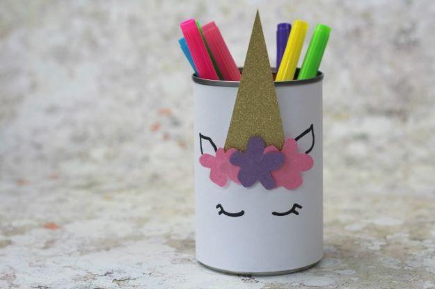 Unicorn pencil holder made from a white wrapped tin can, with a gold paper horn and a felt flower mane