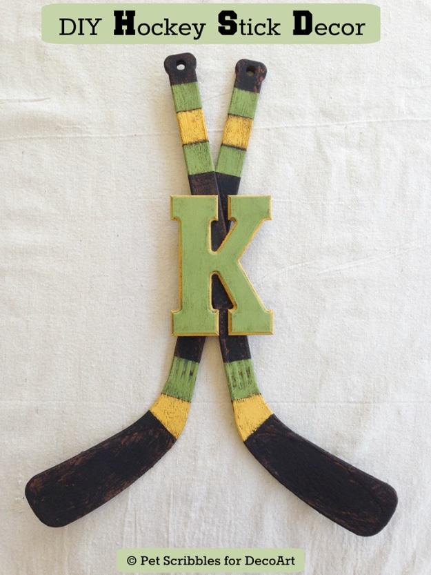 Two crossed hockey sticks painted to look like chipped vintage wood with a green monogram letter K over them