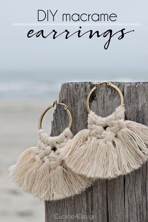DIY macrame earrings in cream cotton cord knotted onto gold hoops, fanned and trimmed, against a weathered wood post