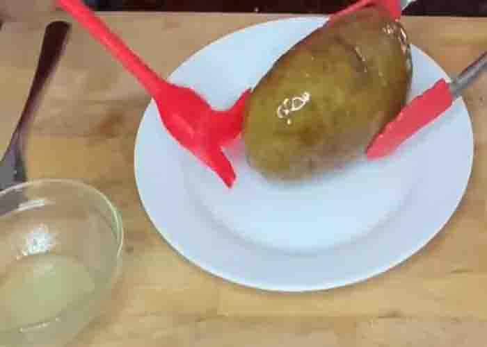 Brushing the potato with duck fat to make the skin crispier