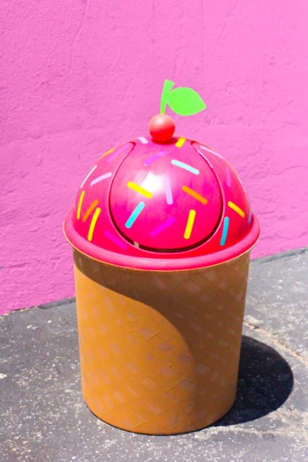 Ice cream cone trash can with a hot pink domed lid, painted sprinkles and a cherry, over a tan waffle cone base