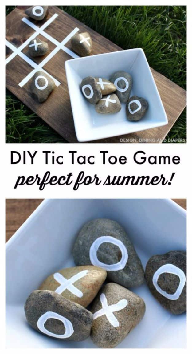 DIY tic tac toe game board with a stained wood base, white painted grid and rocks marked with X and O