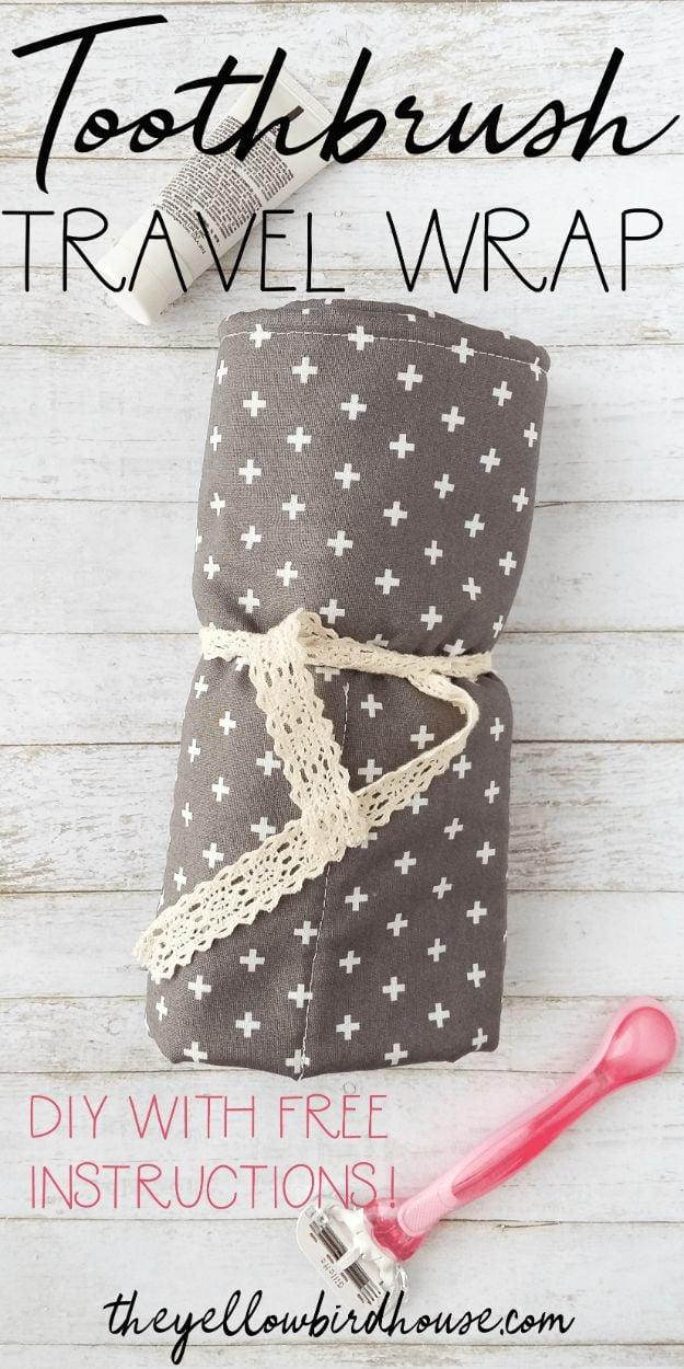 Toothbrush travel wrap in grey cross print cotton rolled and tied with cream lace, a toothbrush and a pink razor alongside