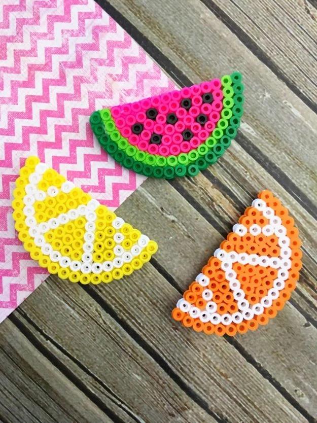 Fruit perler bead magnets, a watermelon lemon and orange slice in fused beads on weathered wood and pink chevron