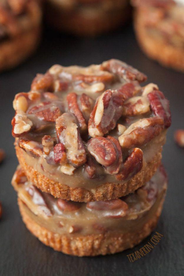 Mini caramel pecan tarts in muffin liners with a nut crust and chopped toasted pecans set in caramel