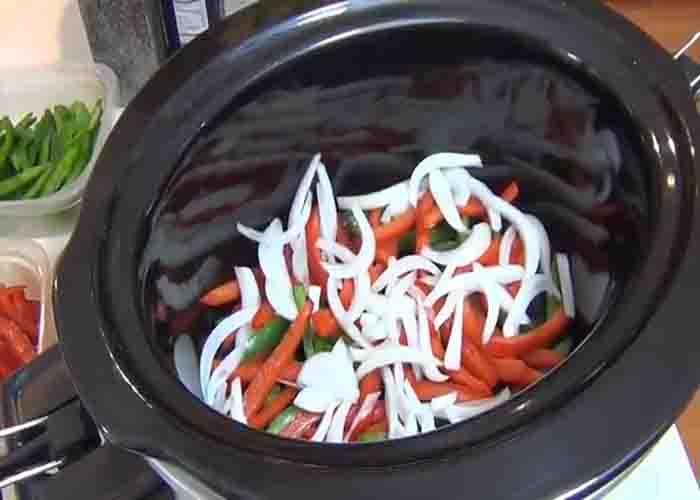 Adding the bell peppers on the slow cooker