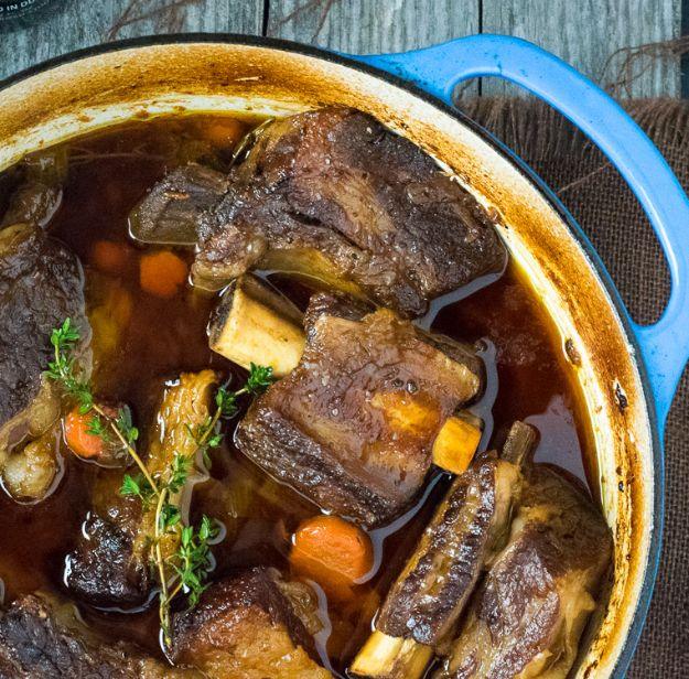 Beer braised short ribs cooked in a dutch oven with stout, carrots and celery until they are fork tender