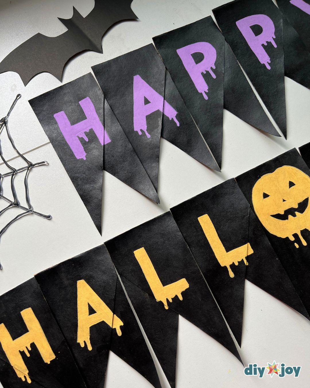 Happy Halloween banner - the full bunting with the pumpkin letter O strung on ribbon, a favorite toilet paper roll craft.