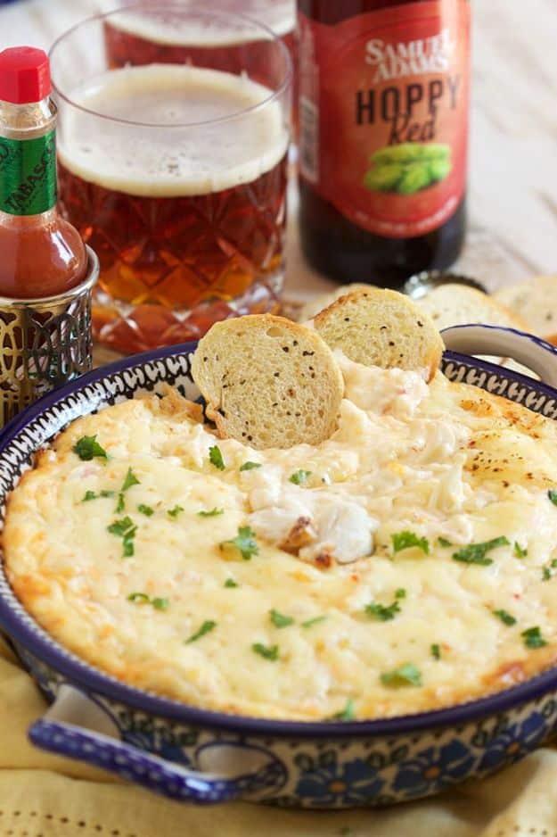 Best hot crab dip baked golden in a dish with big pieces of lump crab meat visible through the cheese