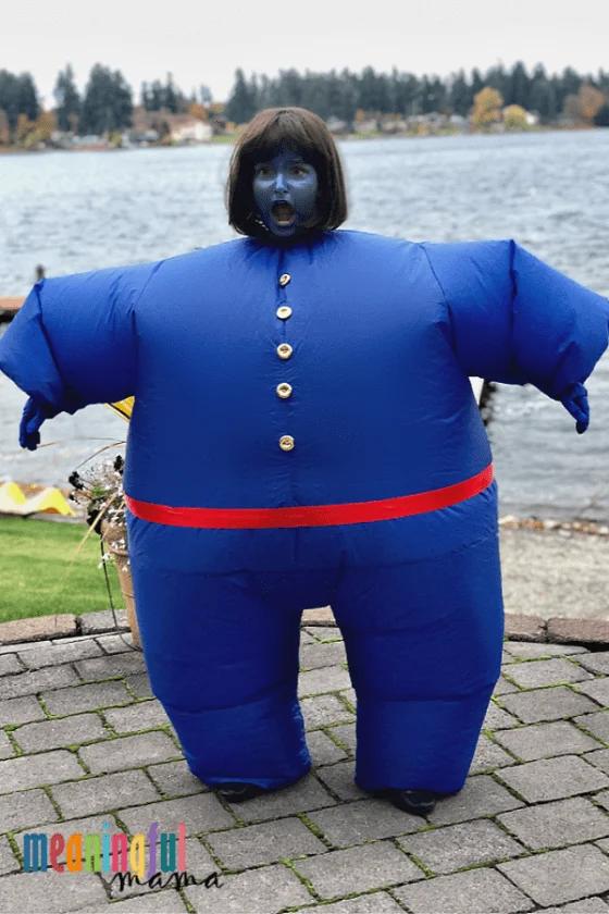 Violet Beauregarde blueberry costume with blue face paint, a dark bob wig, red belt and a round padded blue outfit