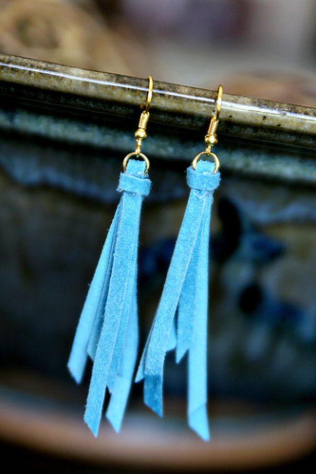 Anthro knockoff tassel earrings in pale blue suede fringe on gold ear wires, hung against a blue glazed pottery bowl
