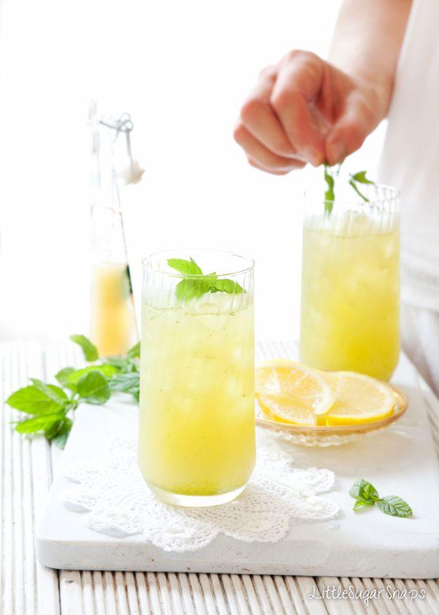 Apple lemon and mint fruit cooler in tall glasses over crushed ice with lemon slices and mint being added