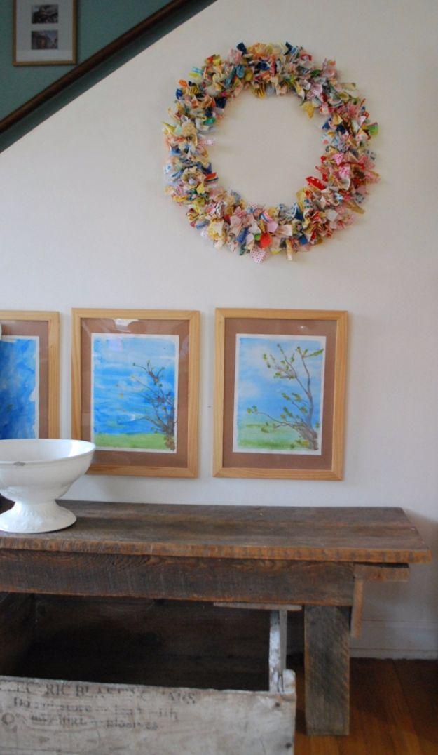 Quilting scraps fabric wreath in pink blue and yellow strips on a wire frame hung above a rustic wooden bench