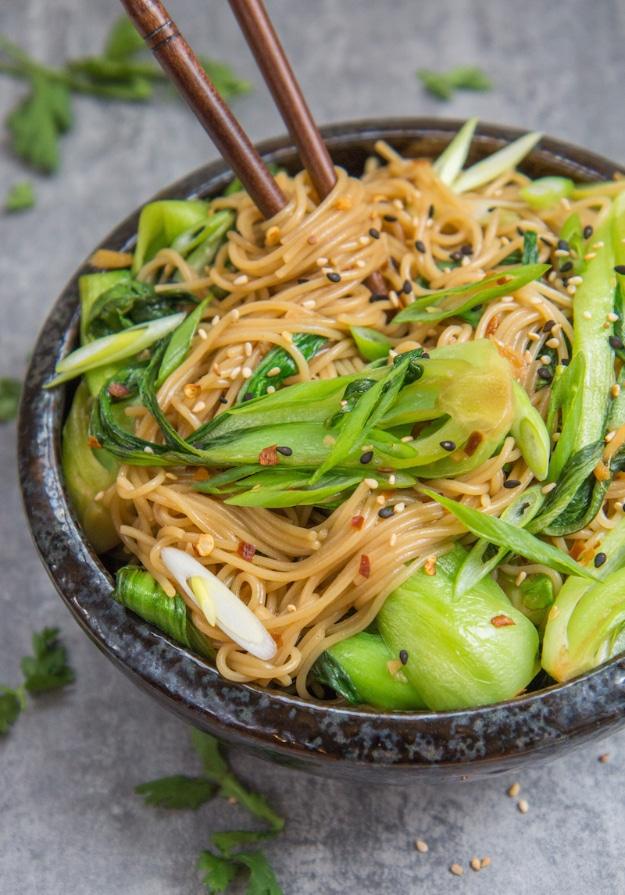Sesame ginger rice noodles with bok choy tossed in a glossy sauce and finished with sesame seeds ready to serve at home