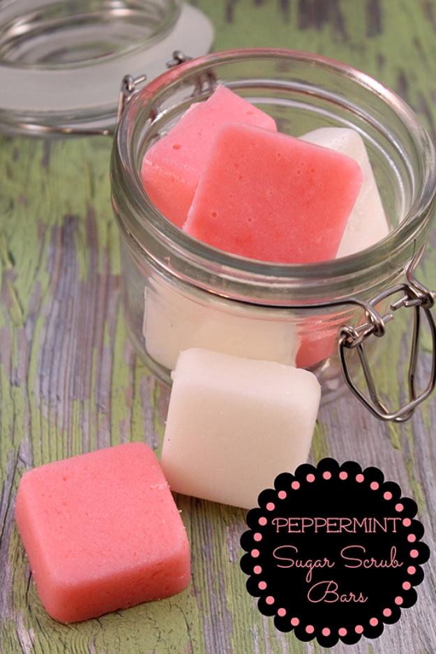 DIY peppermint sugar scrub bars, pink and white squares in a clamp lid jar and two on green painted wood