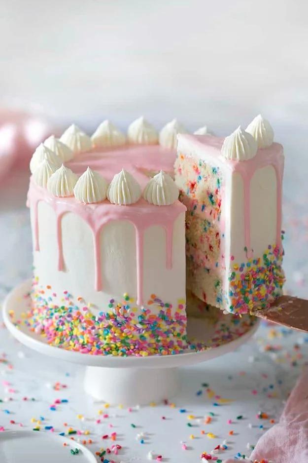 Funfetti layer cake with white crumb full of colorful sprinkles and sweet buttercream frosting recipe for a celebration