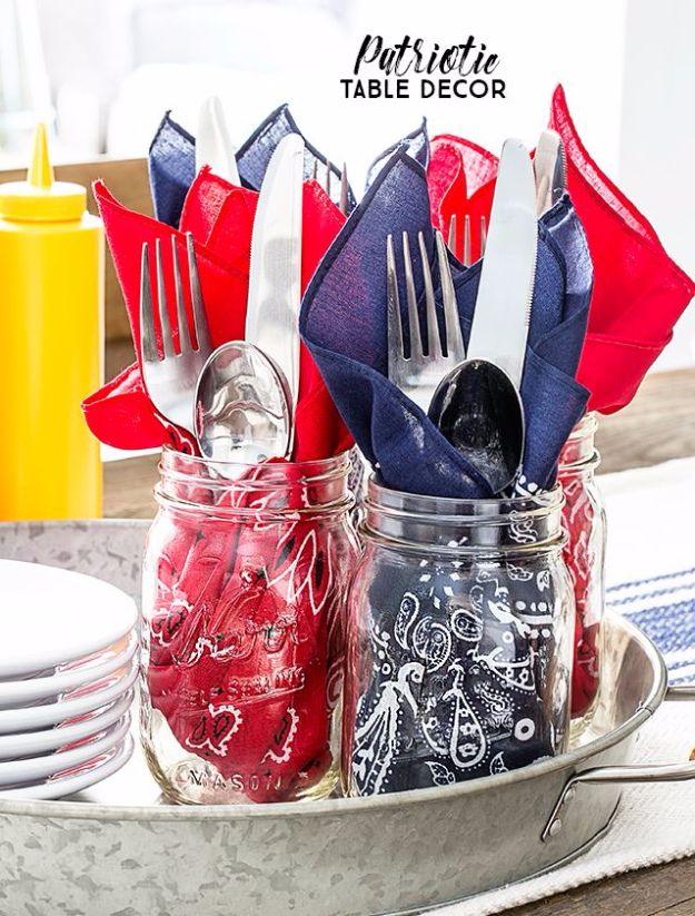 Patriotic bandana table decor, red and navy napkins and silverware in painted mason jars on a metal tray
