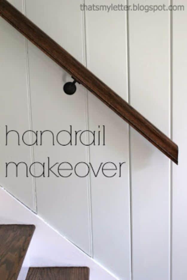 Dark stained wooden handrail mounted on black brackets against a white painted board and batten stairwell wall