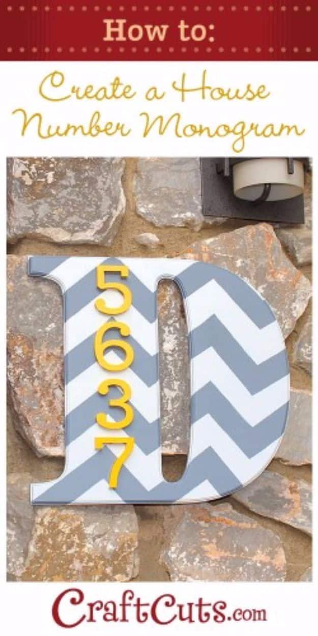 Grey and white chevron painted monogram letter D with yellow house numbers, mounted on a stone porch wall