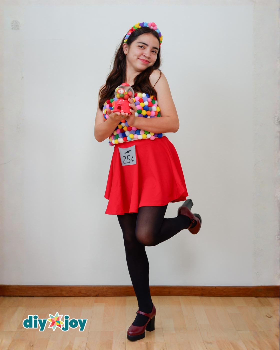 Kids Halloween Costumes - full body shot of the gumball machine costume, toy gumball machine held in both hands