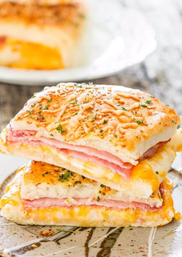 Ham and cheese pockets stacked and cut open to show melted cheddar and ham under a golden parmesan crust