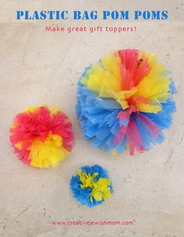 Three plastic bag pom poms in pink, yellow and blue on stone, under a title graphic reading plastic bag pom poms