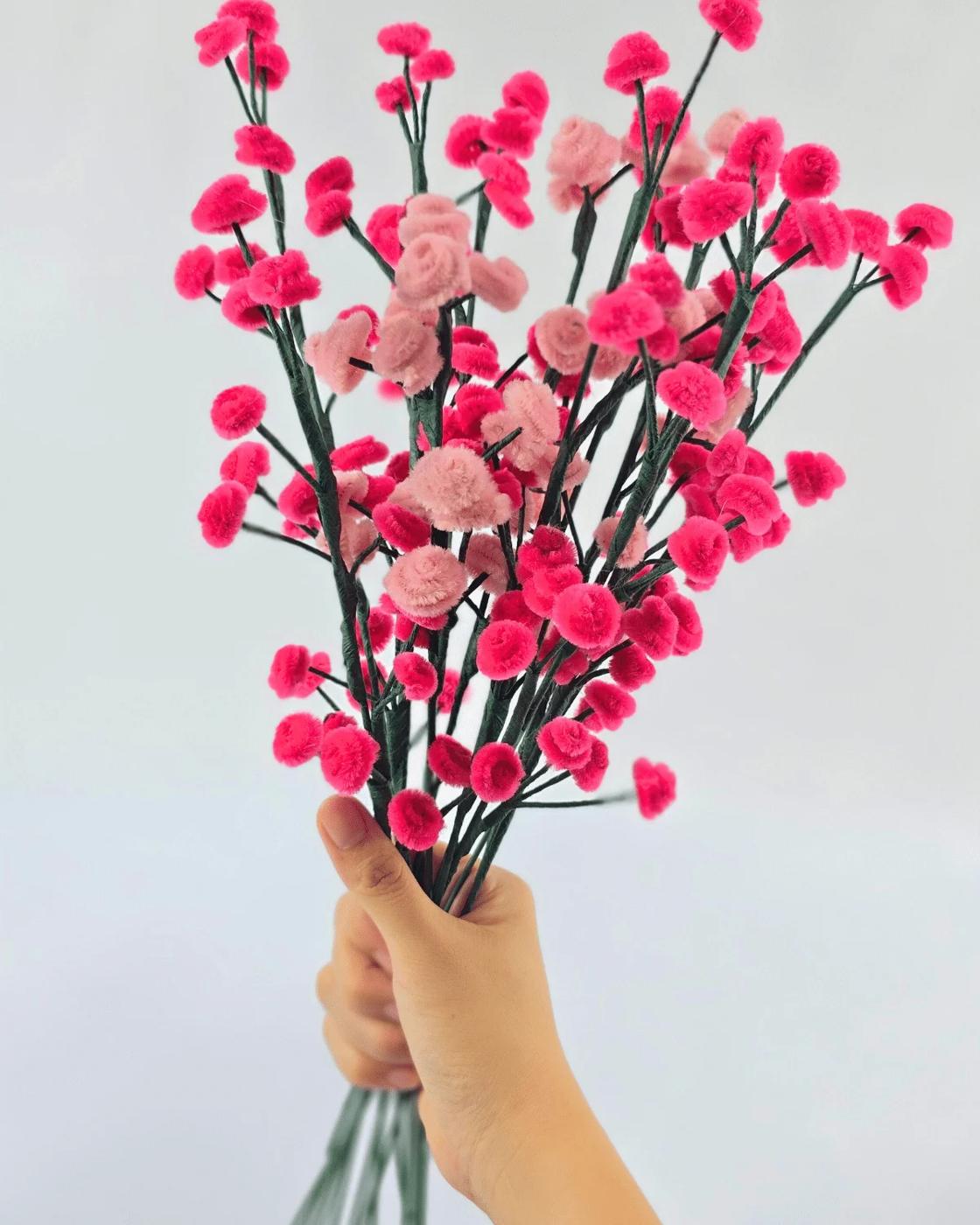 A pipe cleaner flower bouquet of delicate white baby's breath sprays twisted from chenille stems and tied together