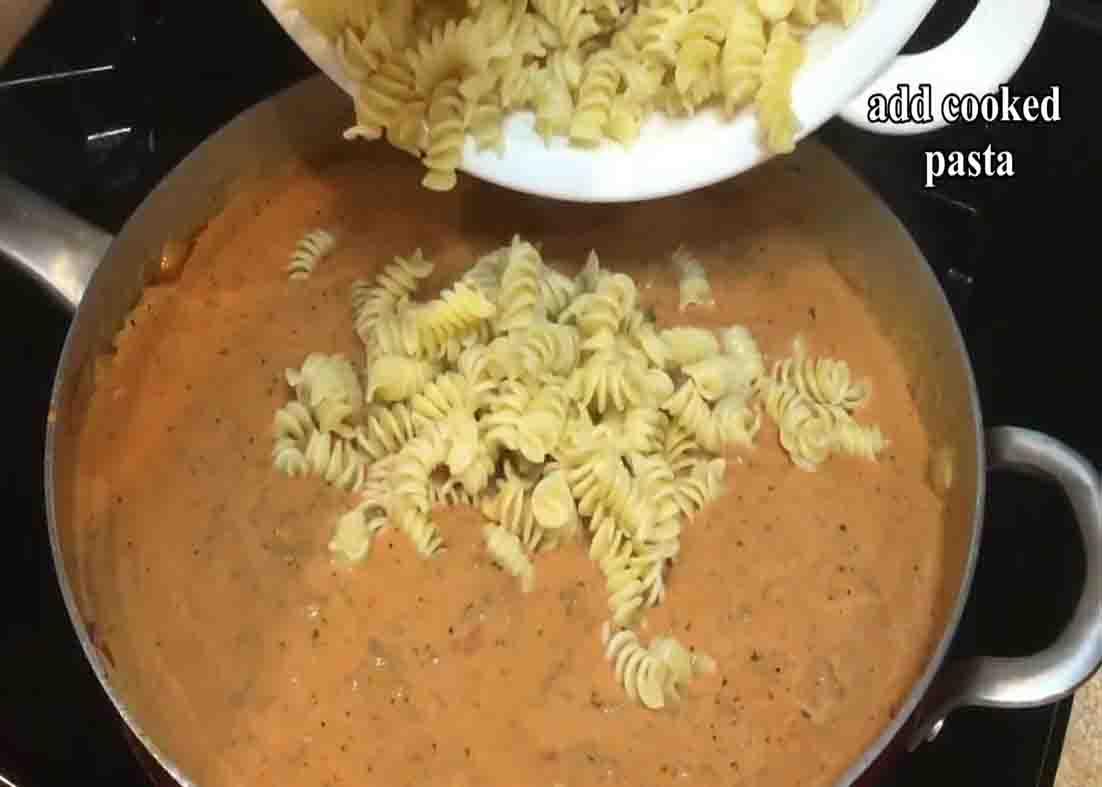 Stirring in the pasta to the beef sauce