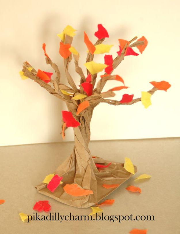 A twisted brown paper bag fall tree with torn orange, red and yellow paper leaves glued to the branches