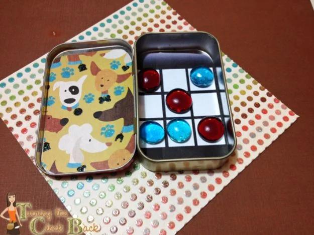 Tic tac toe travel game in an Altoids tin with a printed grid, red and blue glass gems and a dog print paper lid