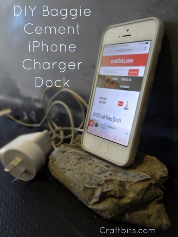Concrete iPhone charger dock, a rough pale tan cast cement block shaped like folded stone propping up an iPhone